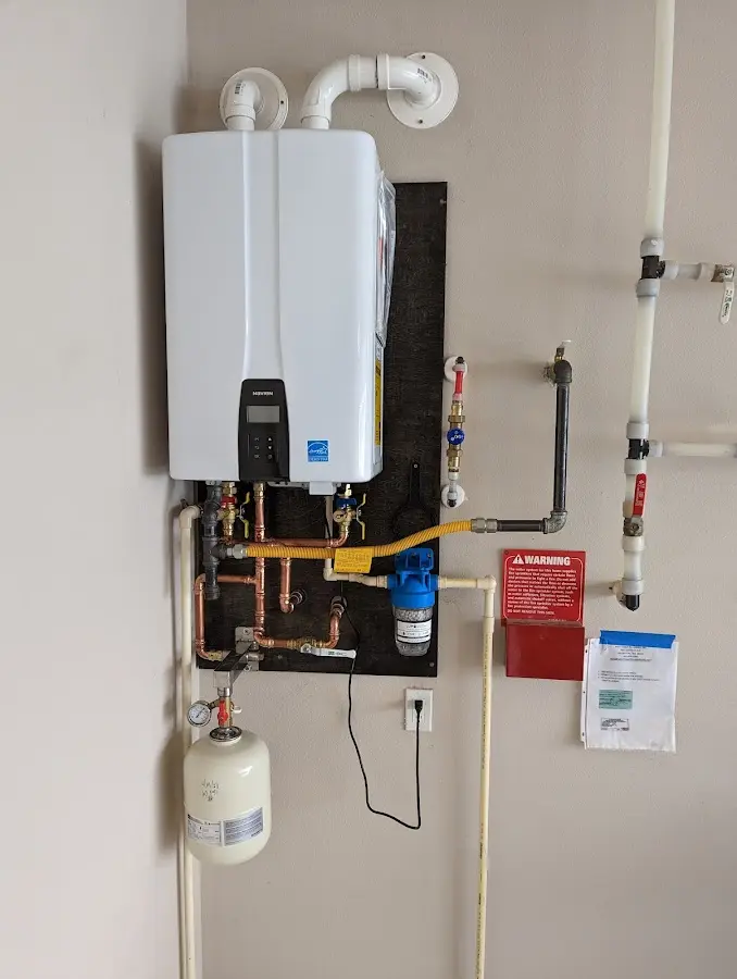 Professional plumber installing copper piping in a Newtown home